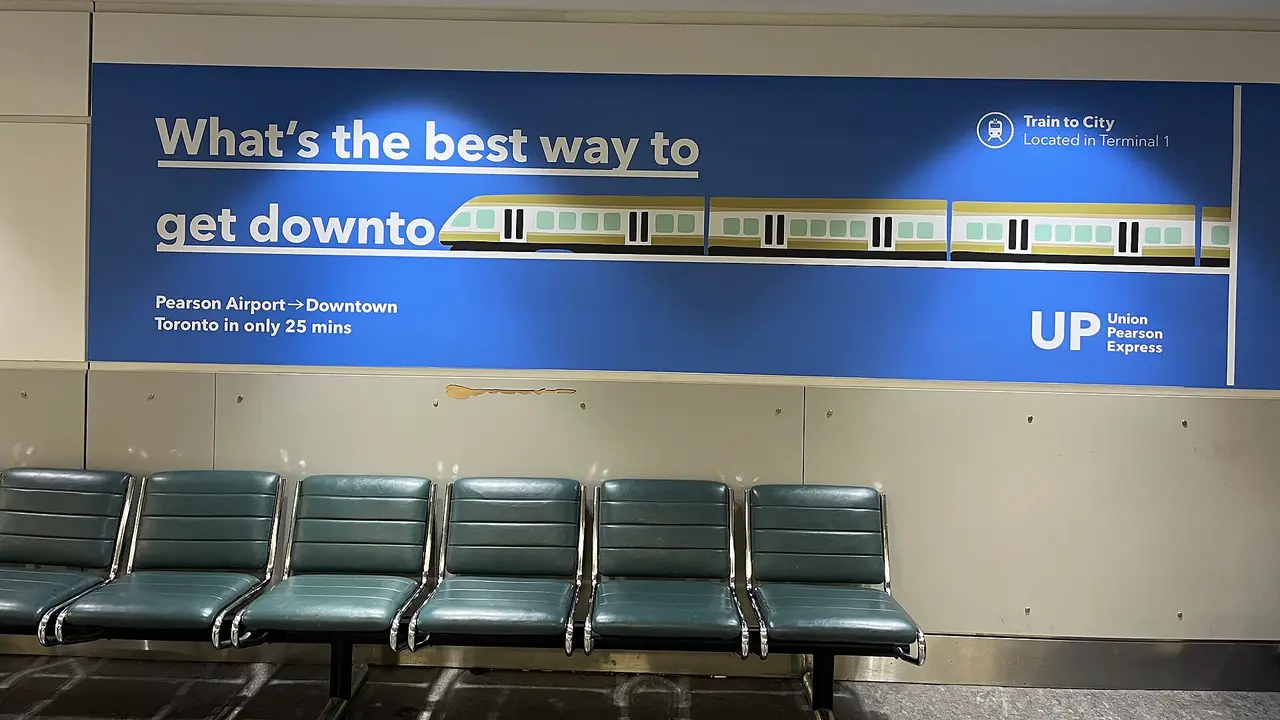 A UP Express advertisement inside Toronto Pearson airport promising downtown in 25 minutes