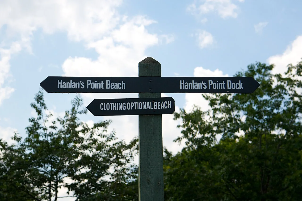 A signpost pointing toward Hanlan's Point Beach and the clothing-optional beach