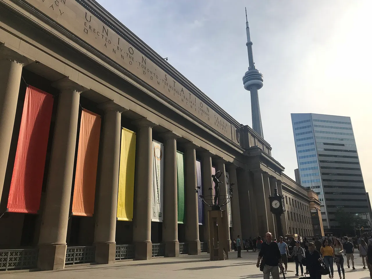 Stone façade of Toronto Union Station with flags along the front colonnade