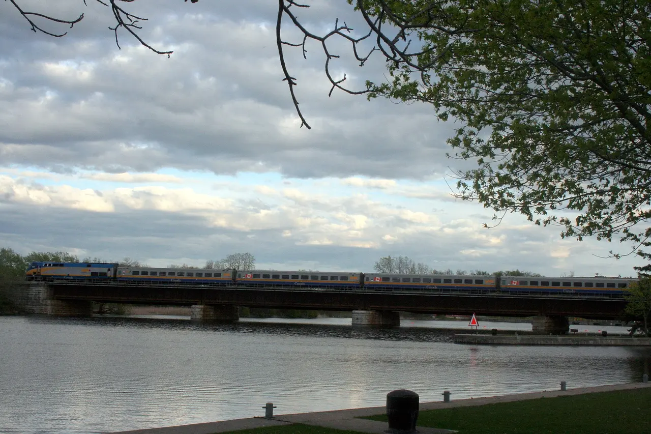 VIA Rail Corridor train crossing a low bridge over open water near Stirling, Ontario