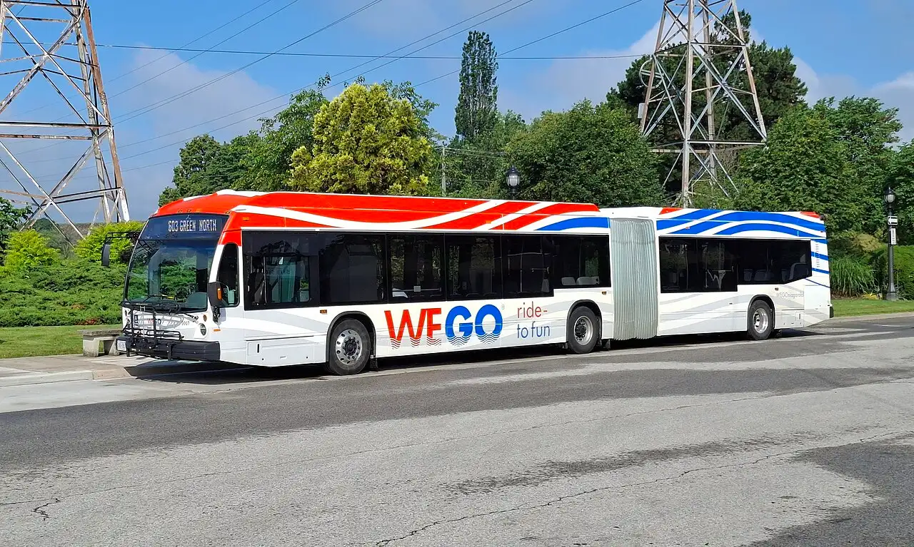 A green and white WEGO shuttle bus stopped beside the Floral Clock on the Niagara Parkway