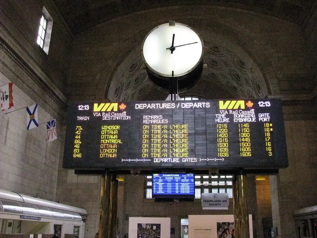 VIA Rail departures board and station clock inside Toronto Union Station