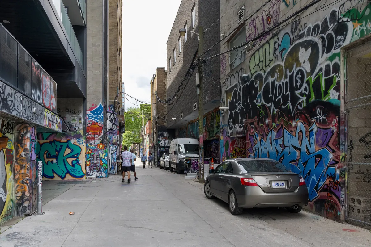 Walls covered in bright street art along Graffiti Alley off Queen Street West