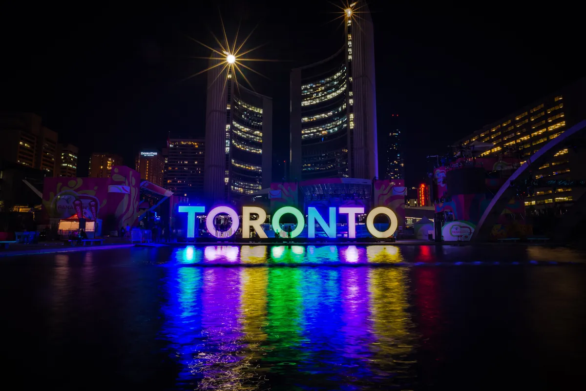 The illuminated multicoloured TORONTO sign on Nathan Phillips Square in front of City Hall