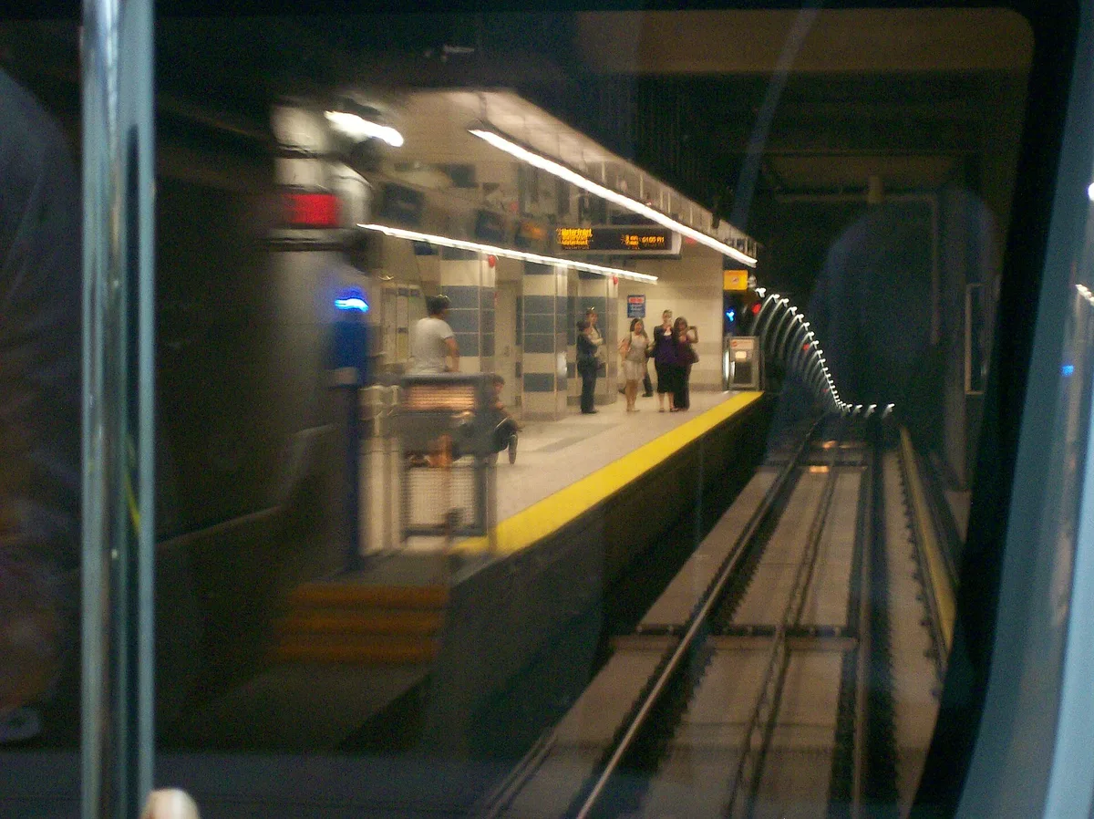 A Canada Line SkyTrain pulling into a station platform in Vancouver
