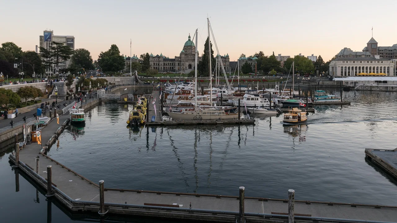Victoria Inner Harbour at dusk, moored yachts and water taxis in front of the domed Parliament Buildings