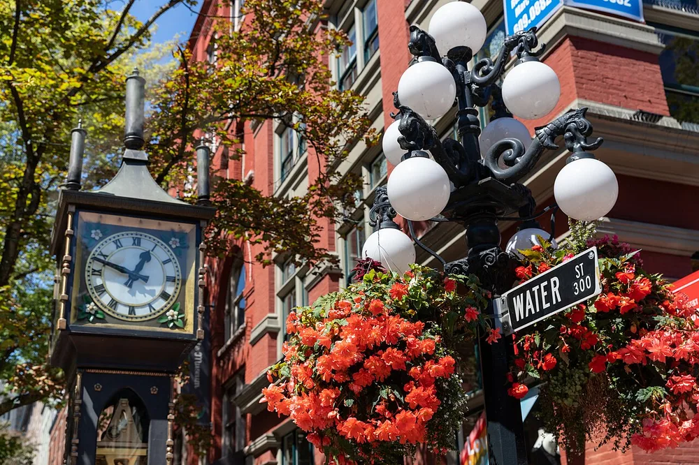 The Gastown Steam Clock on a cobbled corner of Water Street venting steam from its top