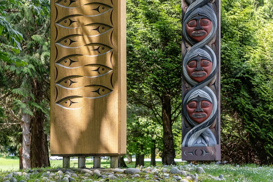 A row of carved and painted totem poles standing at Brockton Point in Stanley Park