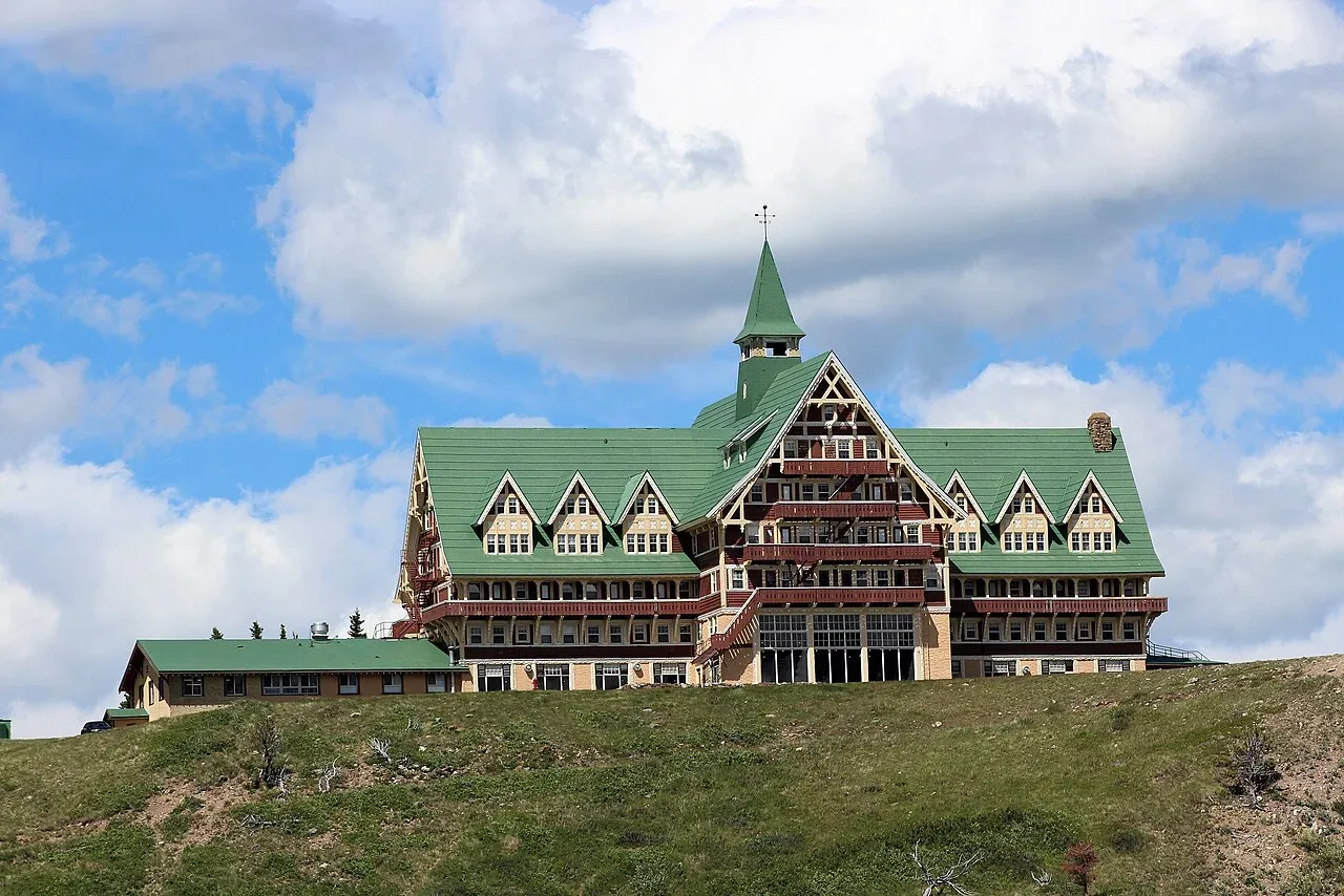 The Prince of Wales Hotel on a bluff above Waterton Lake with mountains rising straight from the water