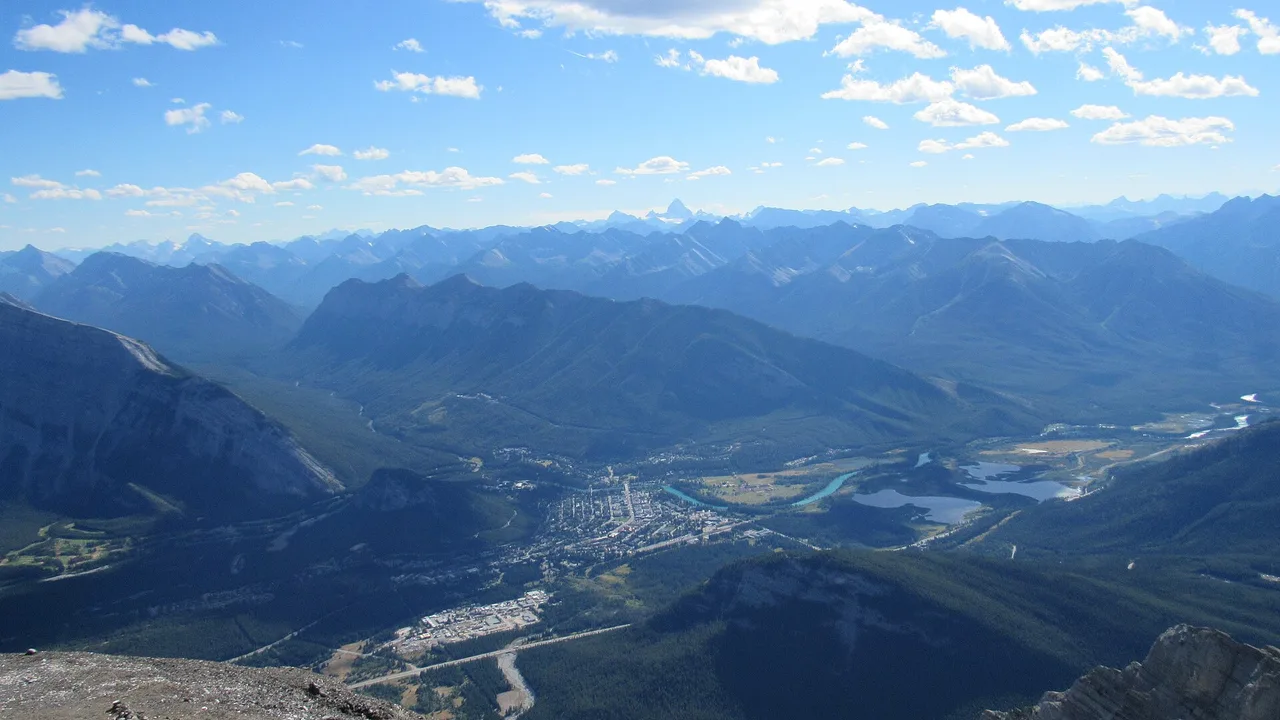 The town of Banff far below in the Bow Valley, seen from the summit of Cascade Mountain with ranges stretching to the horizon