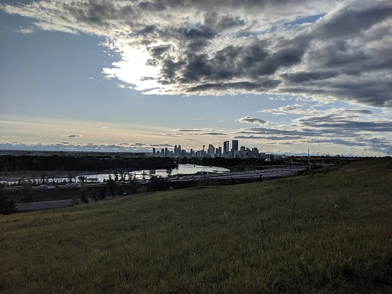 Looking across downtown Calgary towers with the Bow River and pathways in the foreground