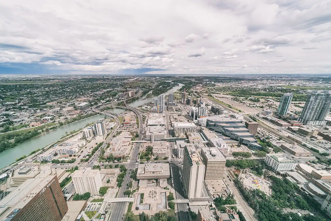 Modern residential towers and landscaped paths in Calgary East Village beside the Bow River