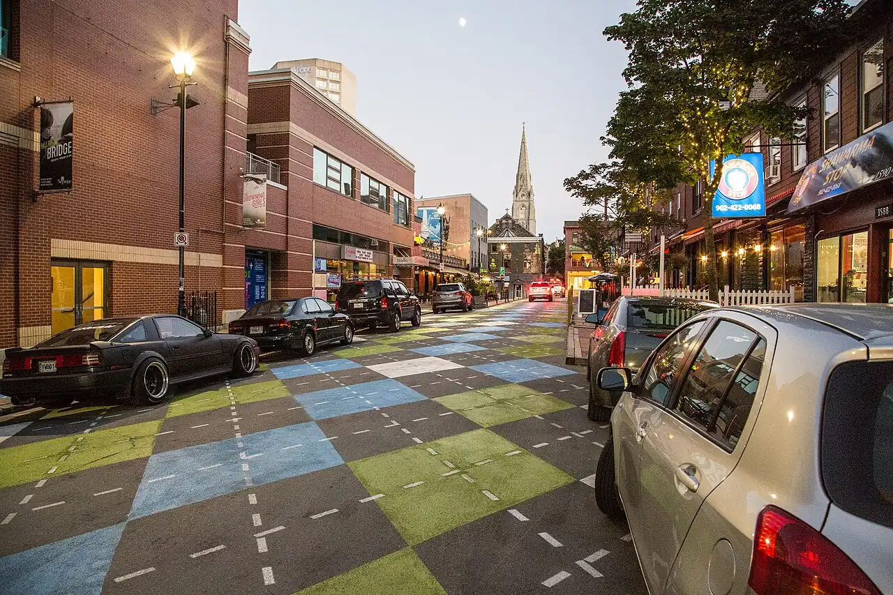 Argyle Street in Halifax at dusk with its argyle-paved roadway, patios and a church spire at the end of the street