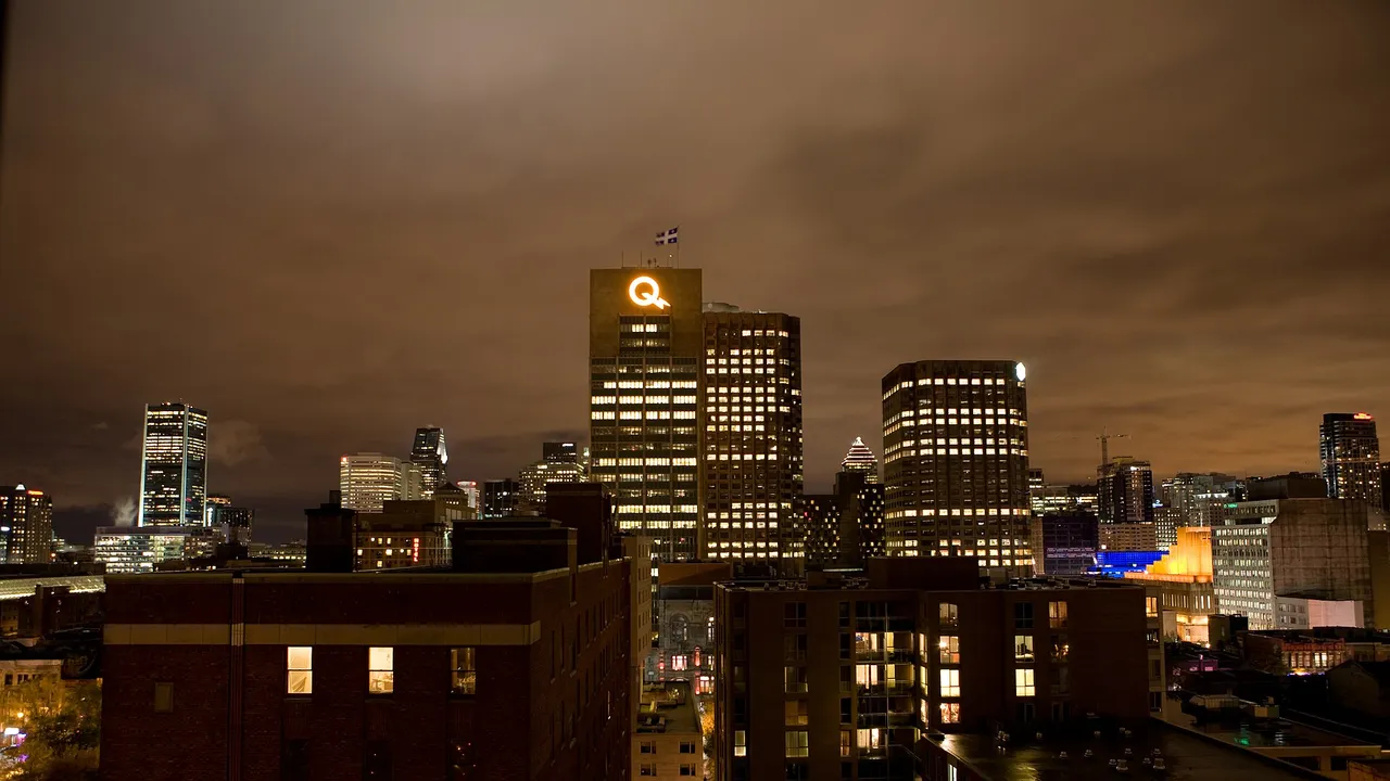The downtown Montreal skyline lit up at night, its office towers over the Ville-Marie district
