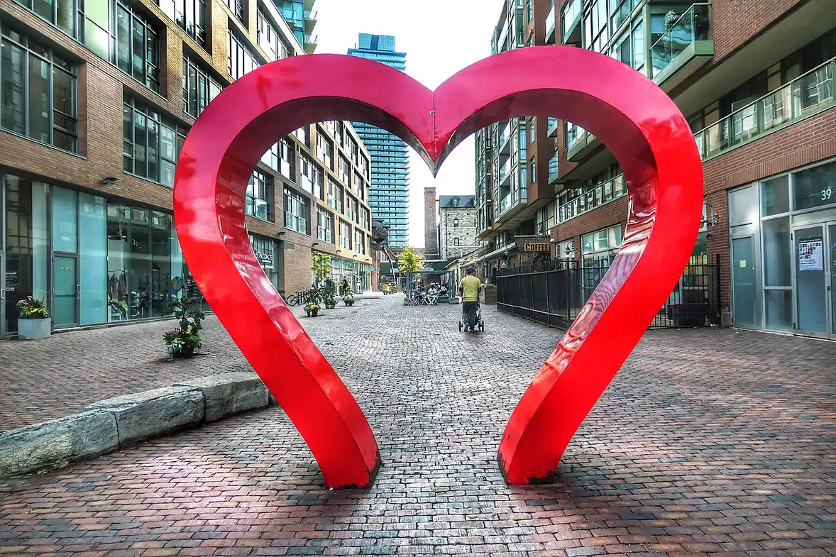 A red heart art installation on a cobbled lane in the Distillery District, Toronto