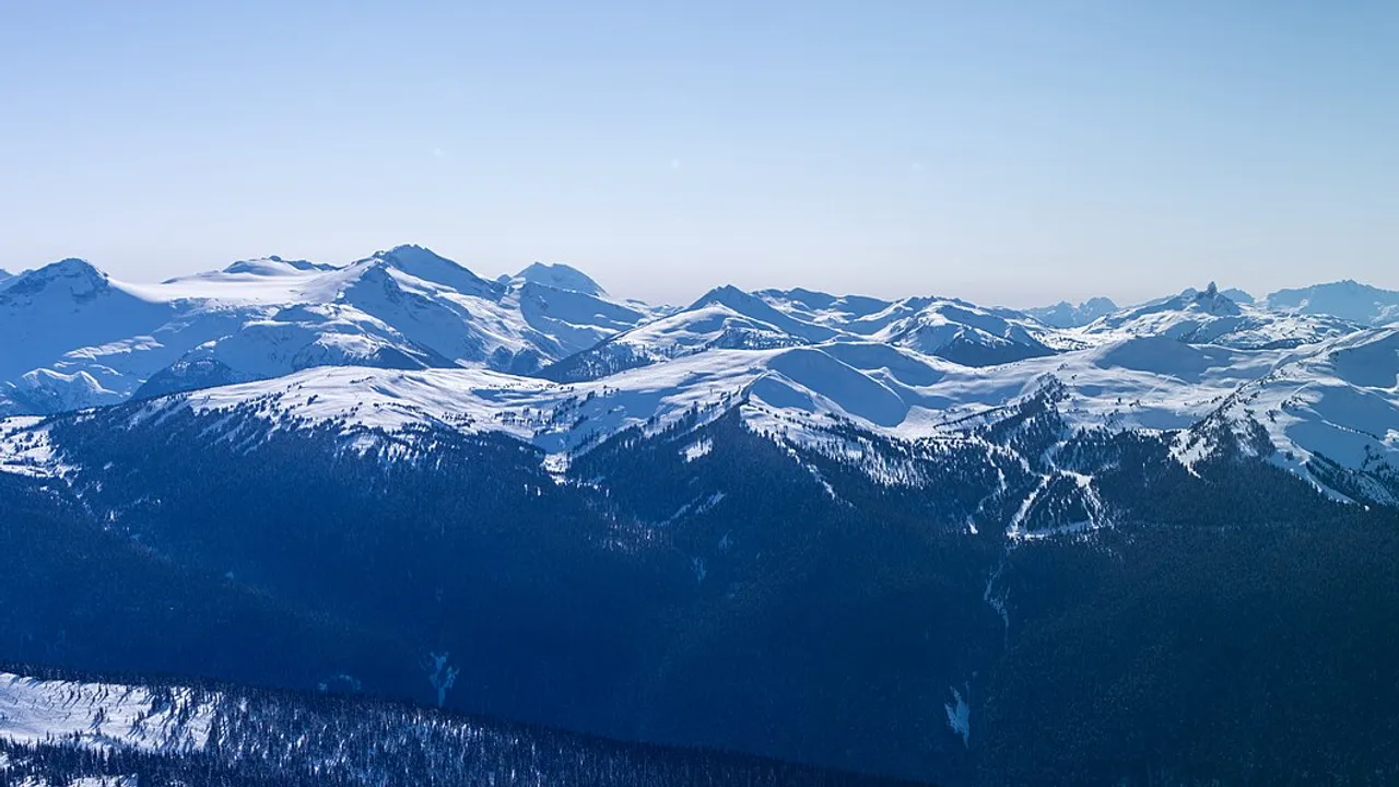Whistler Mountain and the snow-dusted Coast Mountains under a blue sky