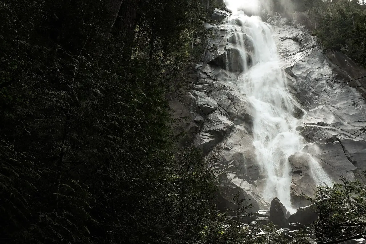 Shannon Falls cascading down a forested cliff beside the Sea-to-Sky Highway near Squamish