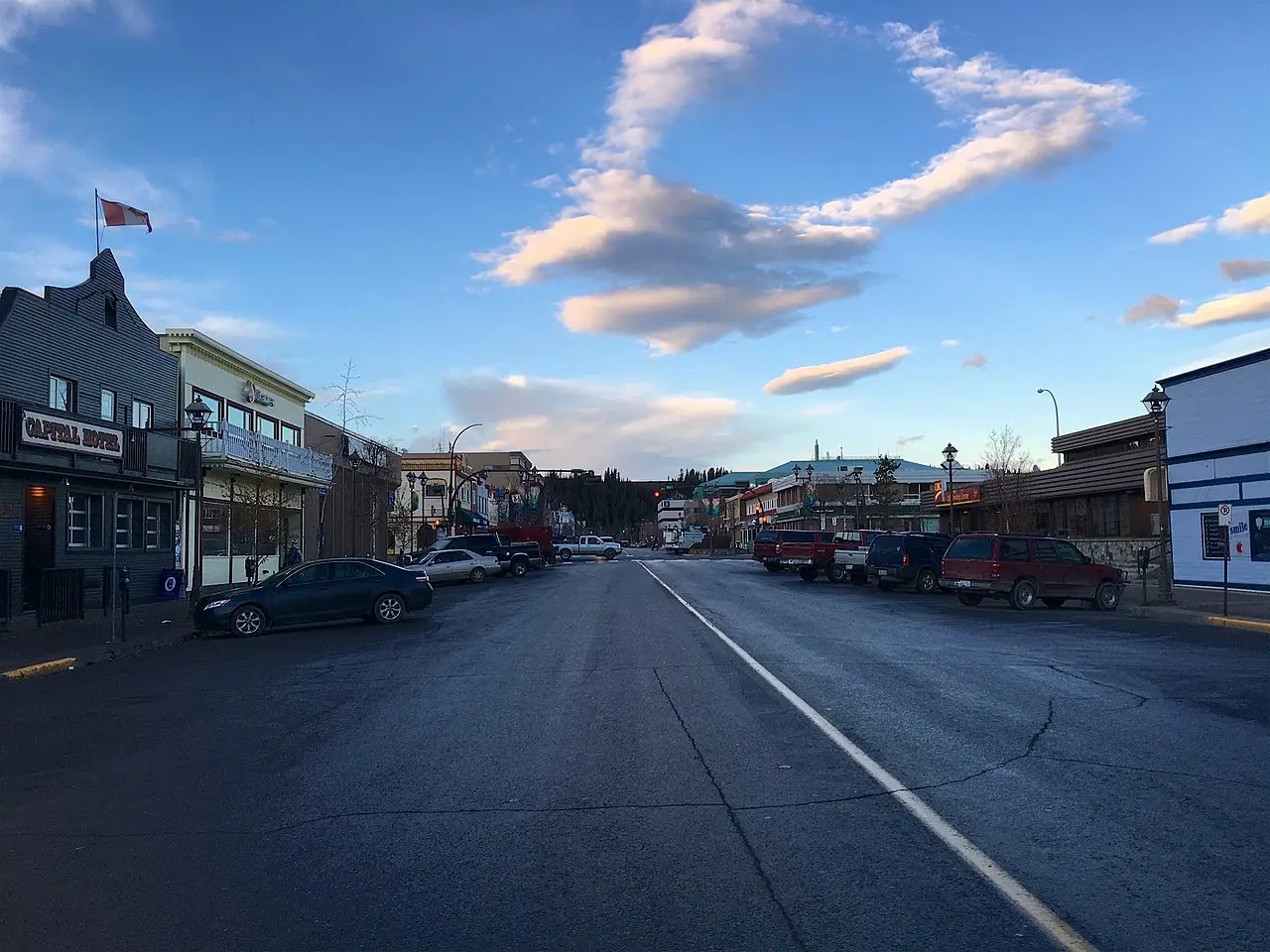 Downtown Whitehorse street with mountains rising behind commercial buildings