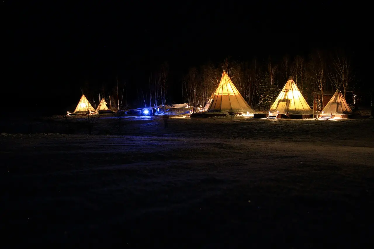 Traditional teepees at Aurora Village near Yellowknife under winter night sky